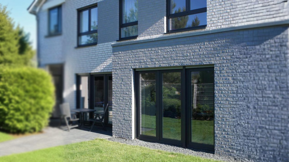 Moderne Kunststofffenster in anthrazit an einem Neubau mit Garten