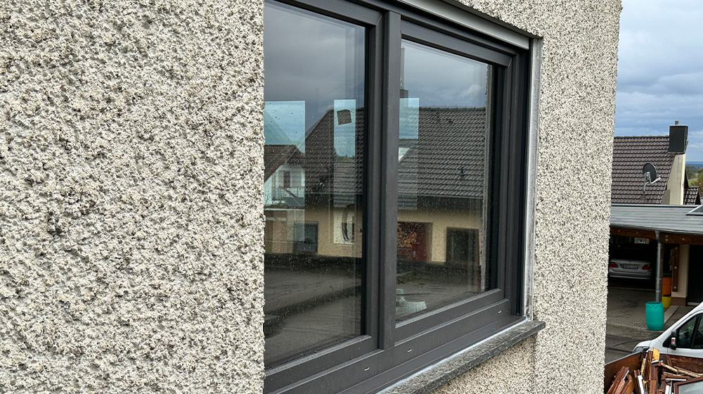 Detailansicht eines neuen Kunststofffensters in anthrazit mit Wärmeschutzverglasung