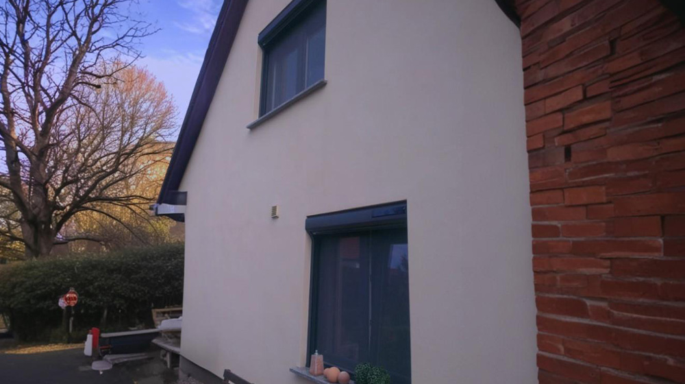 Rollladen nachgerüstet an Einfamilienhaus mit heller Fassade