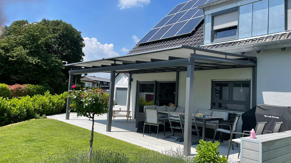 Offenes Terrassendach ohne Seitenwände mit gemütlichem Sitzbereich im Garten