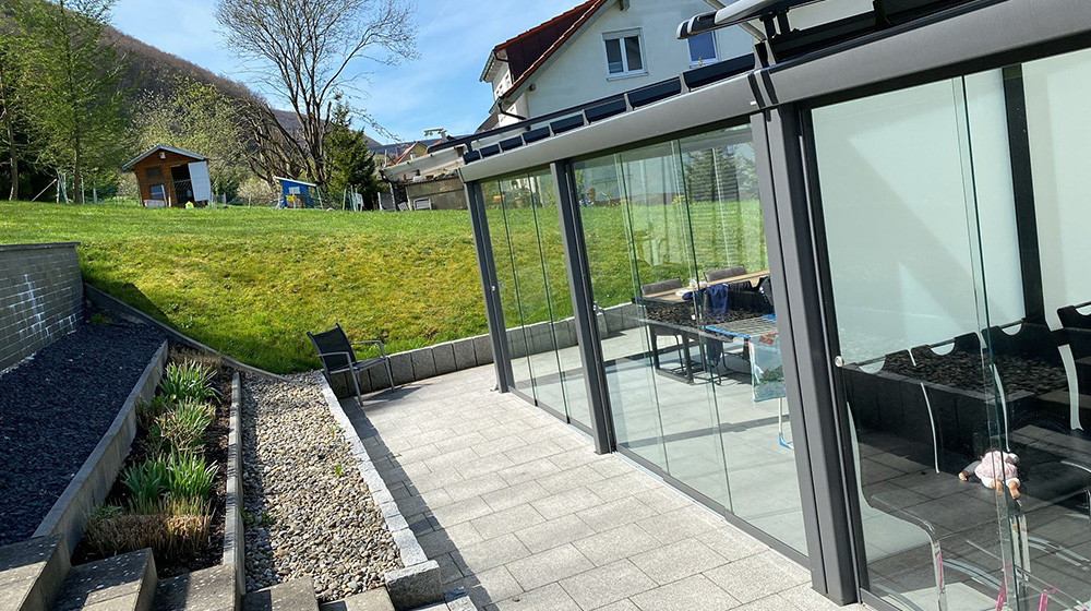 Terrassendach mit Glasfront und Schiebetüren – transparenter Schutz für Gartenbereiche