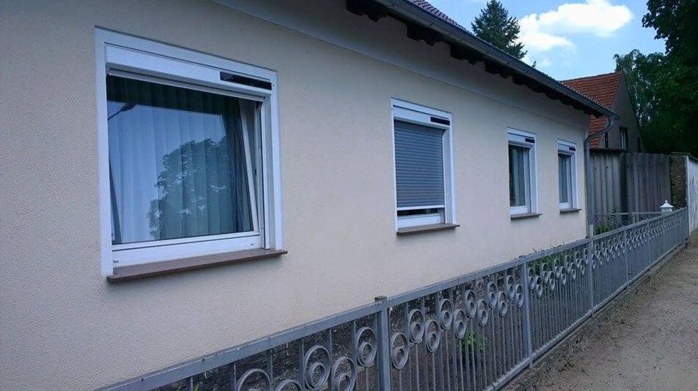 Mehrere Fenster mit nachgerüsteten Vorbaurollläden an einem Einfamilienhaus